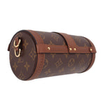 Side view of monogram crossbody trunk bag with gold hardware and curved flap