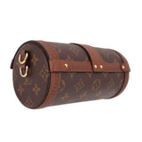 Side view of monogram crossbody trunk bag with gold hardware and curved flap