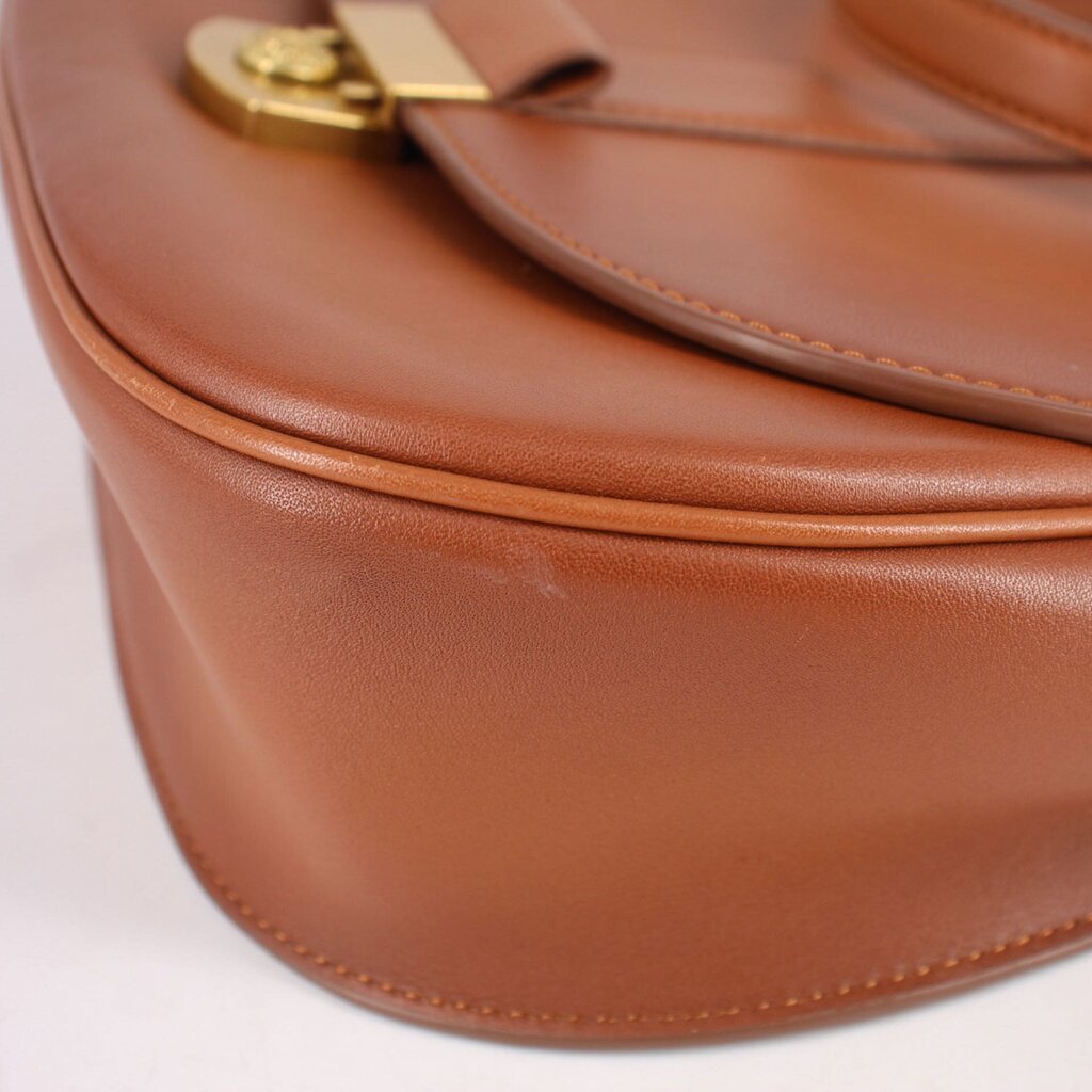 Cognac leather crossbody bag close-up of curved panel and edge stitching