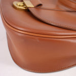Cognac leather crossbody bag close-up of curved panel and edge stitching
