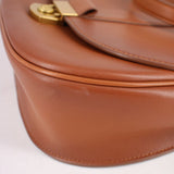 Cognac leather crossbody bag close-up of curved panel and edge stitching