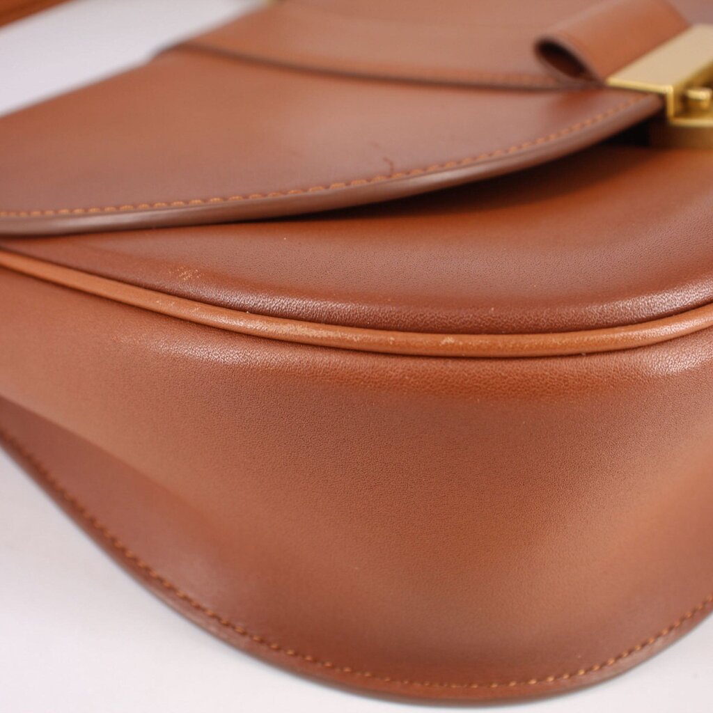 Cognac leather crossbody bag close-up of stitched seams and fold-over edge