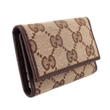 Brown Gucci tri-fold key case, side view, GG monogram canvas with snap flap