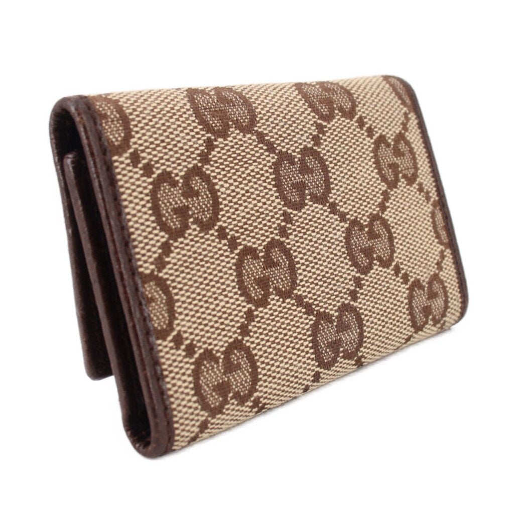 Brown Gucci tri-fold key case, angled view, GG monogram canvas and dark trim