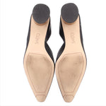 Bottom view of black leather heeled pumps with tan branded footbeds
