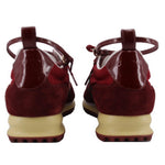 Red suede sneakers from the back with heel pull tabs and beige rugged outsole