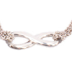 Silver-tone infinity knot bracelet with close-up of linked centerpiece