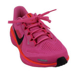 Pink mesh running sneakers with black swoosh, orange midsole, lace-up front.