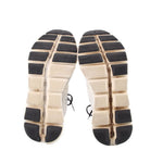 White ON Cloud sneaker outsoles with black tread blocks and grid-pattern cushioning
