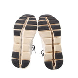 White ON Cloud sneaker outsoles with black tread blocks and grid-pattern cushioning