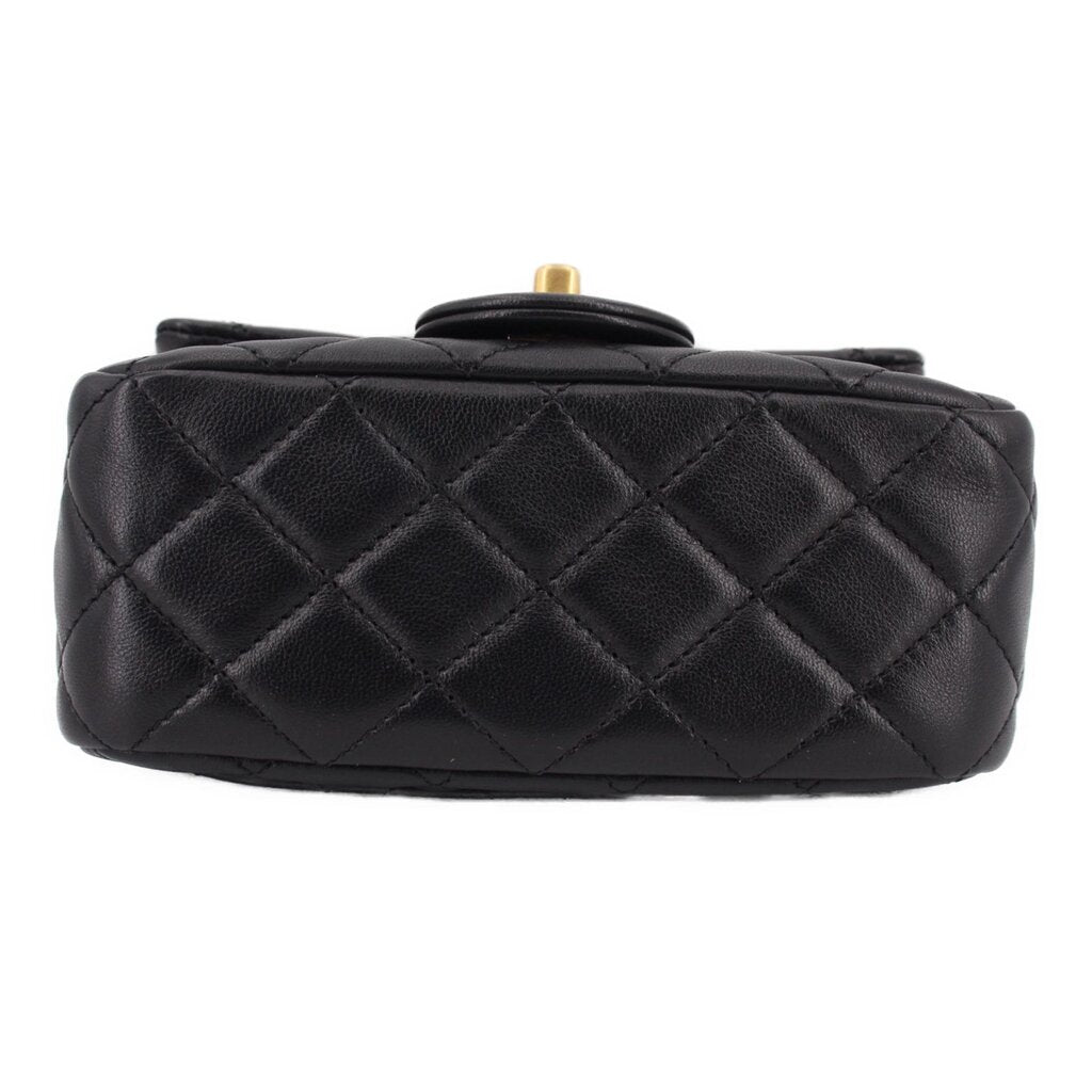 Black quilted mini crossbody bag with diamond pattern and top handle loop