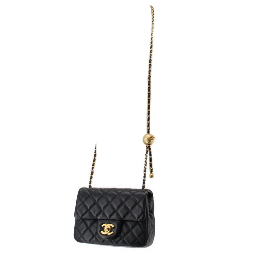 Black quilted mini crossbody bag with gold Chanel logo and short chain shoulder strap