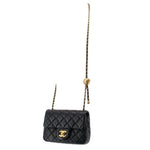 Black quilted mini crossbody bag with gold Chanel logo and short chain shoulder strap