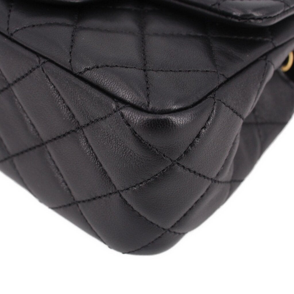 Close-up of black quilted leather mini crossbody bag corner and diamond stitching