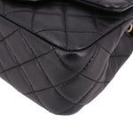 Close-up of black quilted leather mini crossbody bag corner and diamond stitching