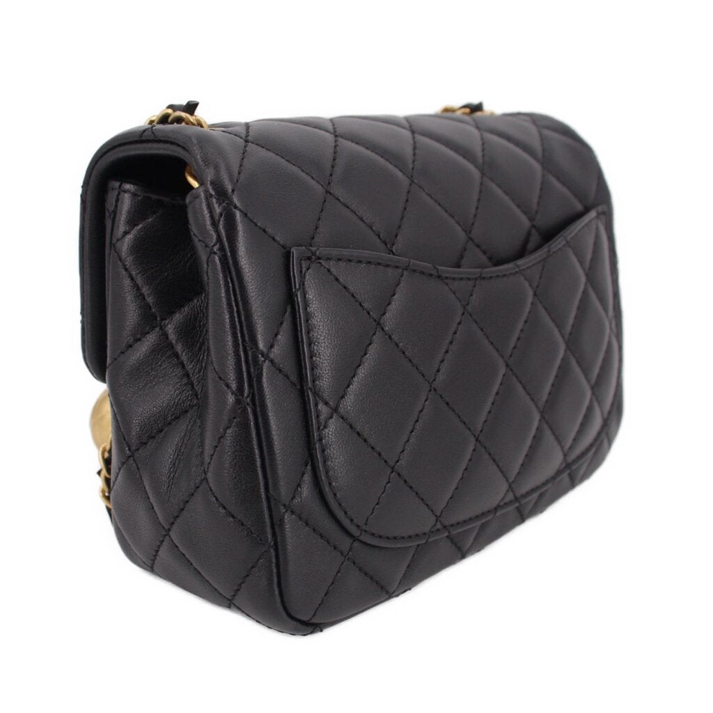 Black quilted mini crossbody bag side angle with flap stitching and gold chain