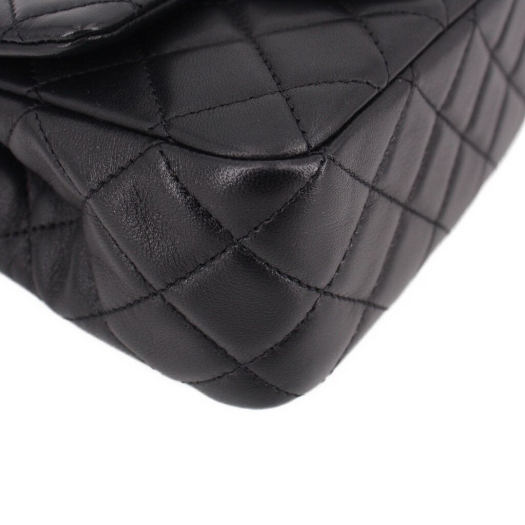 Close-up of black quilted leather mini crossbody bag front quilting with curved seam