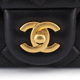 Gold CC turn-lock detail on black quilted mini crossbody bag flap