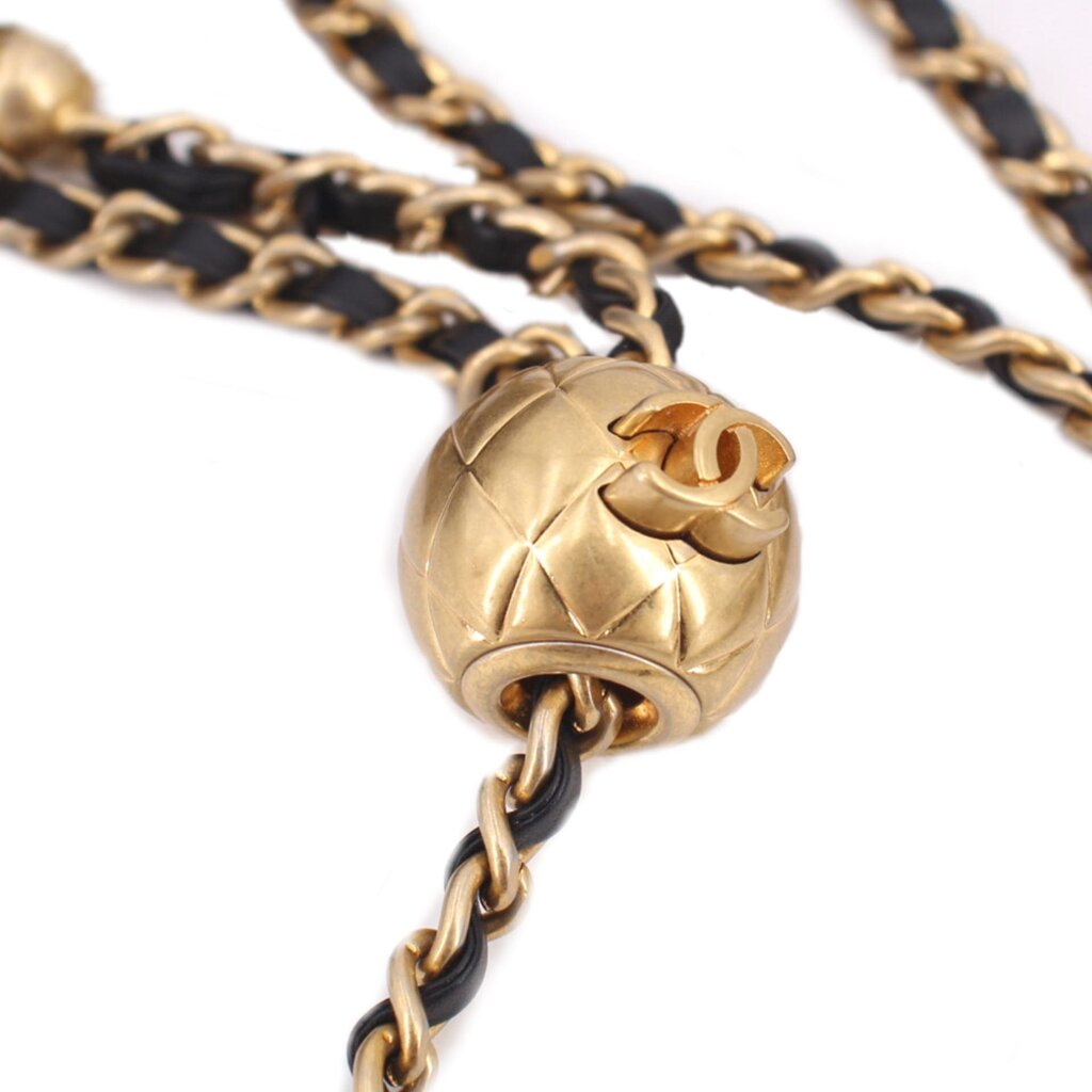 Gold-tone clasp with Chanel logo on dark chain, close-up of mini crossbody bag