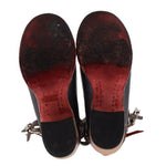 Bottom view of black strappy heels with buckled straps and red insole