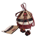 Check canvas bucket crossbody bag with burgundy straps and hanging charm tassels