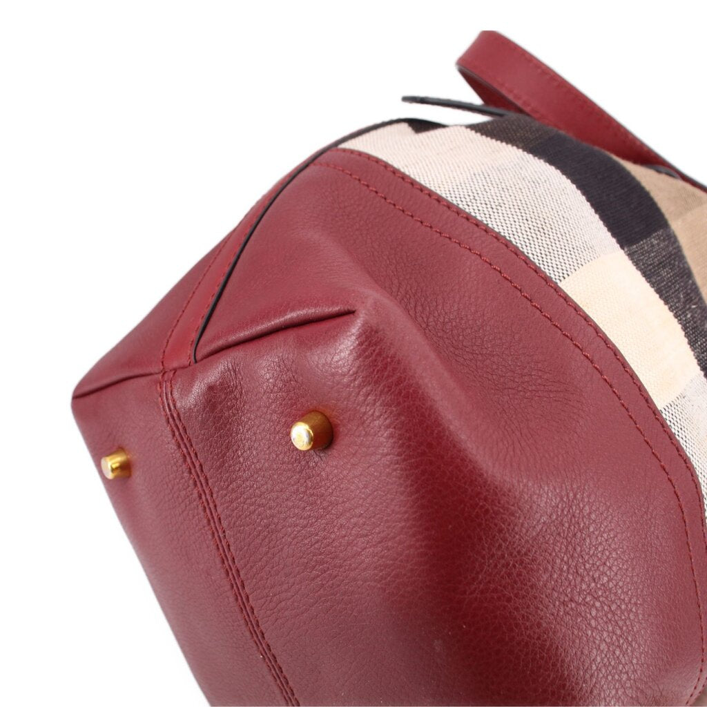 Burgundy leather side of bucket bag with gold-tone hardware and stitched seam