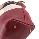Burgundy leather corner with gold-tone stud and check canvas top edge detail