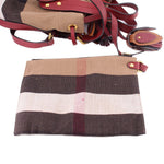 Check canvas bucket crossbody bag with burgundy leather trim and adjustable strap