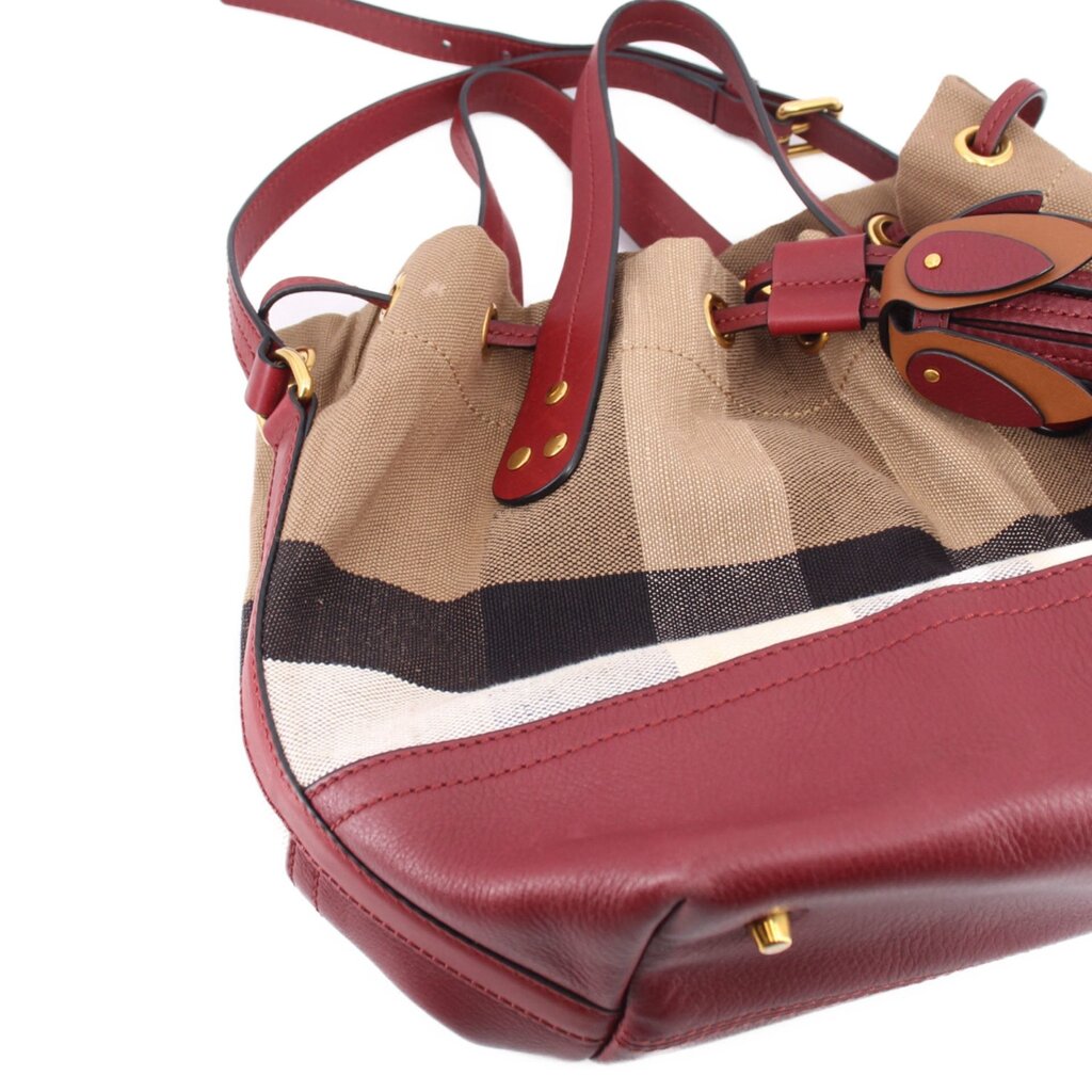Bucket crossbody bag with check pattern top handles, burgundy leather base, gold buckles