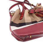 Bucket crossbody bag with check pattern top handles, burgundy leather base, gold buckles