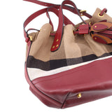 Bucket crossbody bag with check pattern top handles, burgundy leather base, gold buckles
