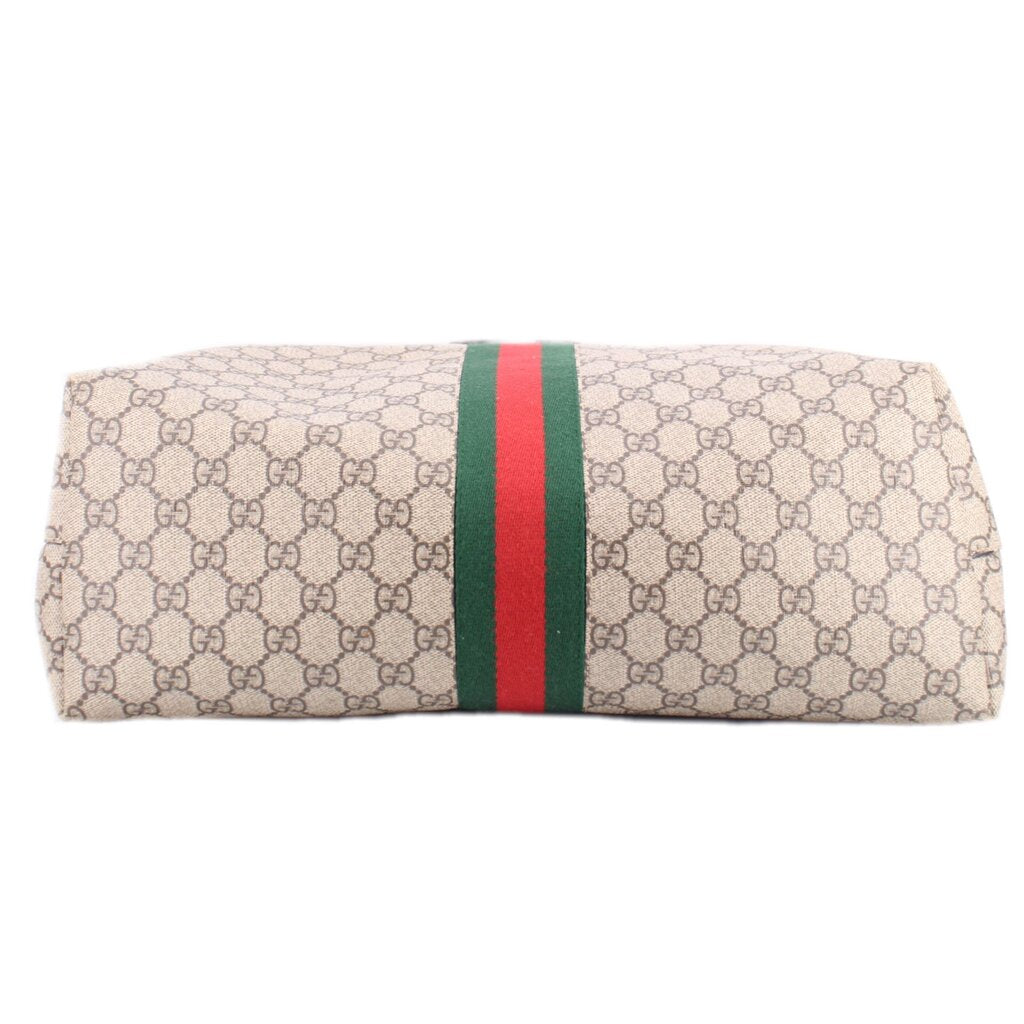 GG canvas tote panel with green-red web stripe and brown leather edge trim.