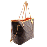 Monogram tote bag with tan leather handles, side seam details, and gold-tone accents