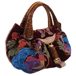 Maroon velvet mini tote bag with woven top handles, ornate embroidery, and front strap charm
