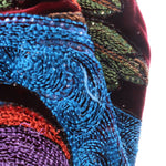 Close-up of blue and green embroidered velvet fabric panel with sparkly thread texture