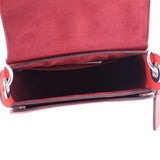 Open red crossbody bag interior with burgundy lining and metal zipper track