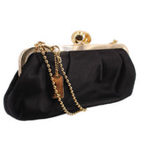 Black satin kisslock shoulder bag with gold frame clasp and dangling chain strap
