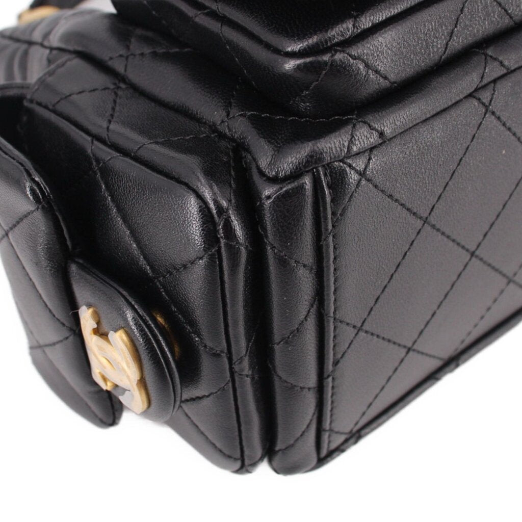 Close-up of black quilted hobo bag front pocket flap and gold-tone clasp