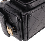 Close-up of black quilted hobo bag front pocket flap and gold-tone clasp