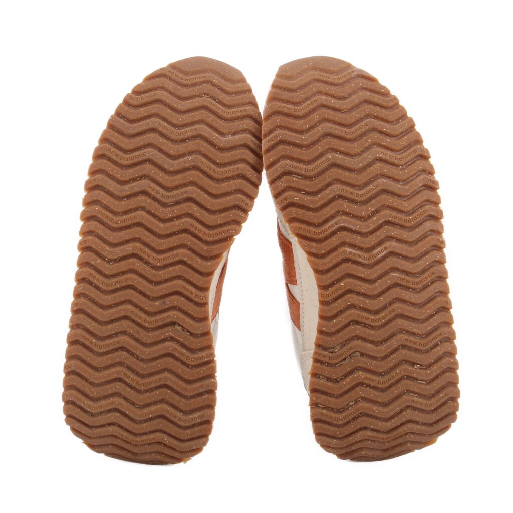 Brown rubber outsoles with zigzag tread pattern on suede sneakers