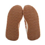 Brown rubber outsoles with zigzag tread pattern on suede sneakers