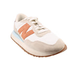 Beige suede sneakers with orange side panels, white laces, and blue accent sole