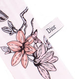 Silk scarf close-up with Dior label and rose-gray floral butterfly design