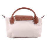 Beige fabric pouch with brown leather handle accents and center top flap