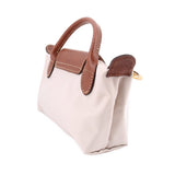 Beige fabric pouch with brown leather straps and top flap, gold-tone hardware