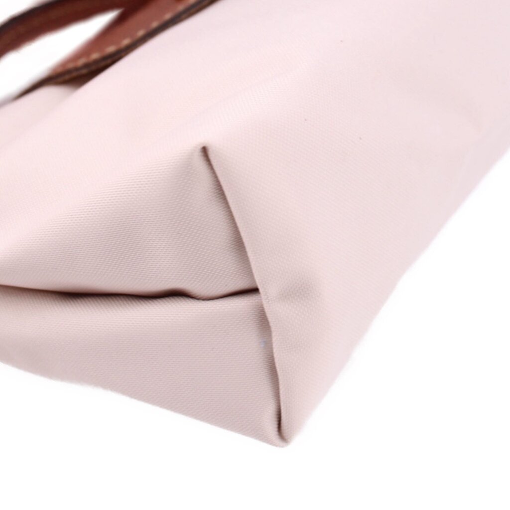 Beige fabric pouch corner with soft fold and brown leather trim detail