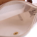 Beige pouch interior with zipper edge, fabric label, and gold snap button