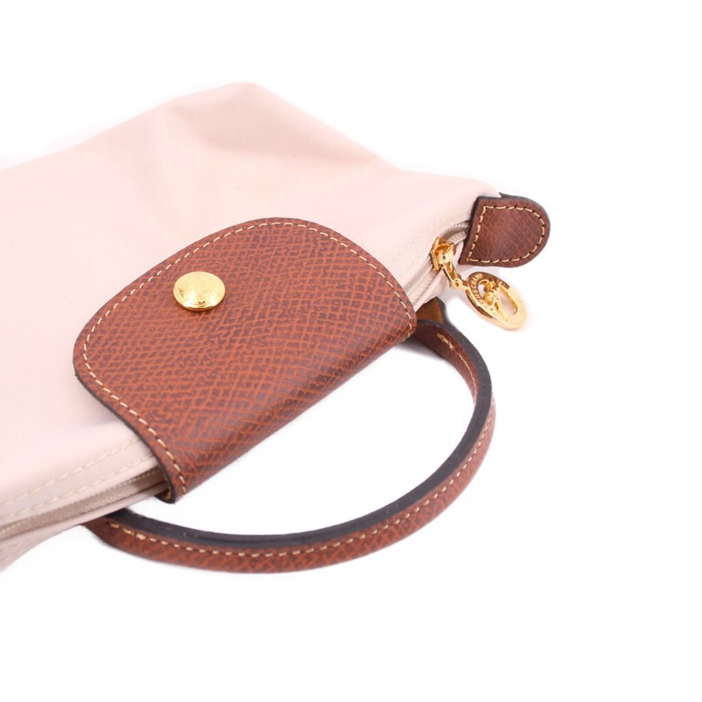 Beige pouch with brown leather zip pull tab, loop handle, and gold hardware