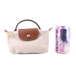 Beige pouch with leather front flap and gold-toned clasp, top handle