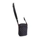 Black quilted phone crossbody bag hanging view with adjustable shoulder strap
